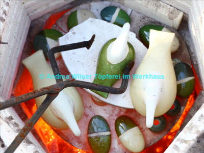 Glühende Keramik wird aus dem Ofen geholt