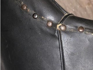 Side of chair showing navy-blue leather, tacks, webbing, and seams /  椅子の側面には、ネイビーブルーの革、鋲、ウェビング、縫い目が見える