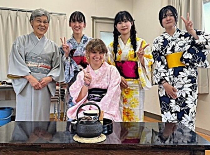 Jewel Perry dressed in a kimono and sitting in front of four people involved with a homestay in Wakayama, 2024. / 和歌山でのホームステイ中に、着物を着たジュウェル・ペリー（前列）, 2024