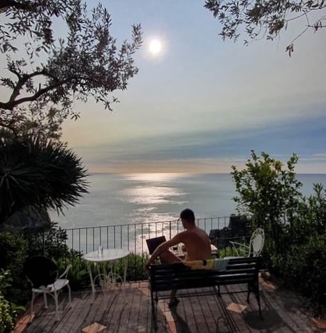 freaky finance, Sizilien, Taormina, Urlaub, Aussicht auf das Meer, Meerblick, Mann auf einer Bank mit PC
