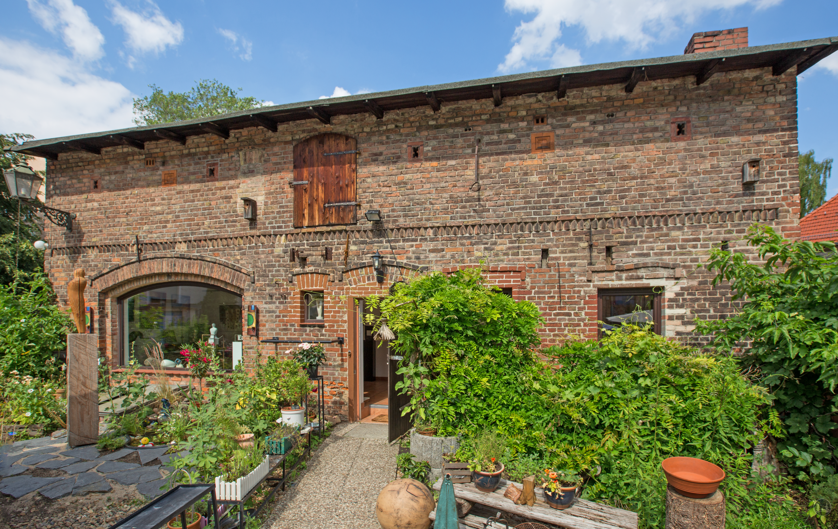 Café im Auenhof und die Kunstgalerie Aagaard im Berliner Stadtteil Hermsdorf. Blick auf die alte Wagenremise, die heute als Kunstgalerie dient.