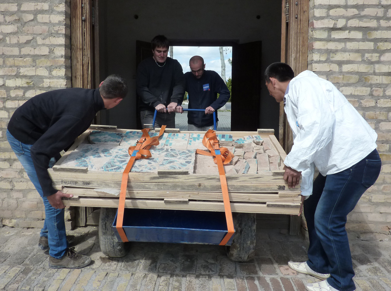 Transport des bacs avec les carreaux restaurés jusqu'au chantier (Socra, 2013)