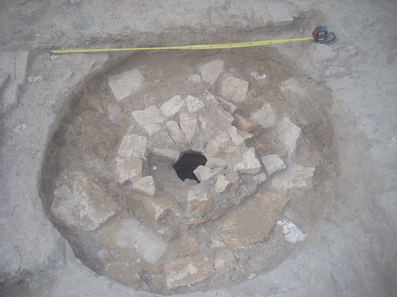 Début du déblaiement du puisard. Le "couvercle" se compose de plusieurs cercles de carreaux de terre cuite (Socra, 2012)