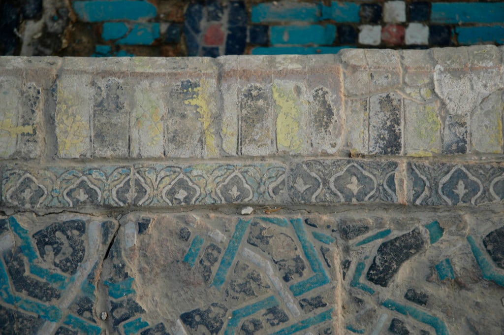 Carreaux de céramique glaçurée polychrome (bleu clair et foncé, blanc, noir, jaune, peut être rouge) formant les angles droits des bassins. (photo : C.Ollagnier, 2008)