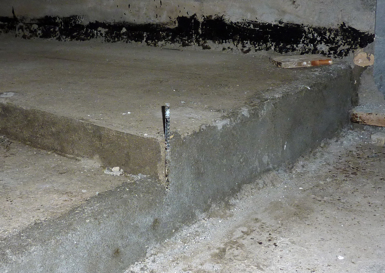 Aperçu de la dalle à la jonction entre la zone 1 (basse) et la zone 3 (haute). Le piquet métallique a servit d'indicateur lors de la coulée du béton (Socra, 2013)