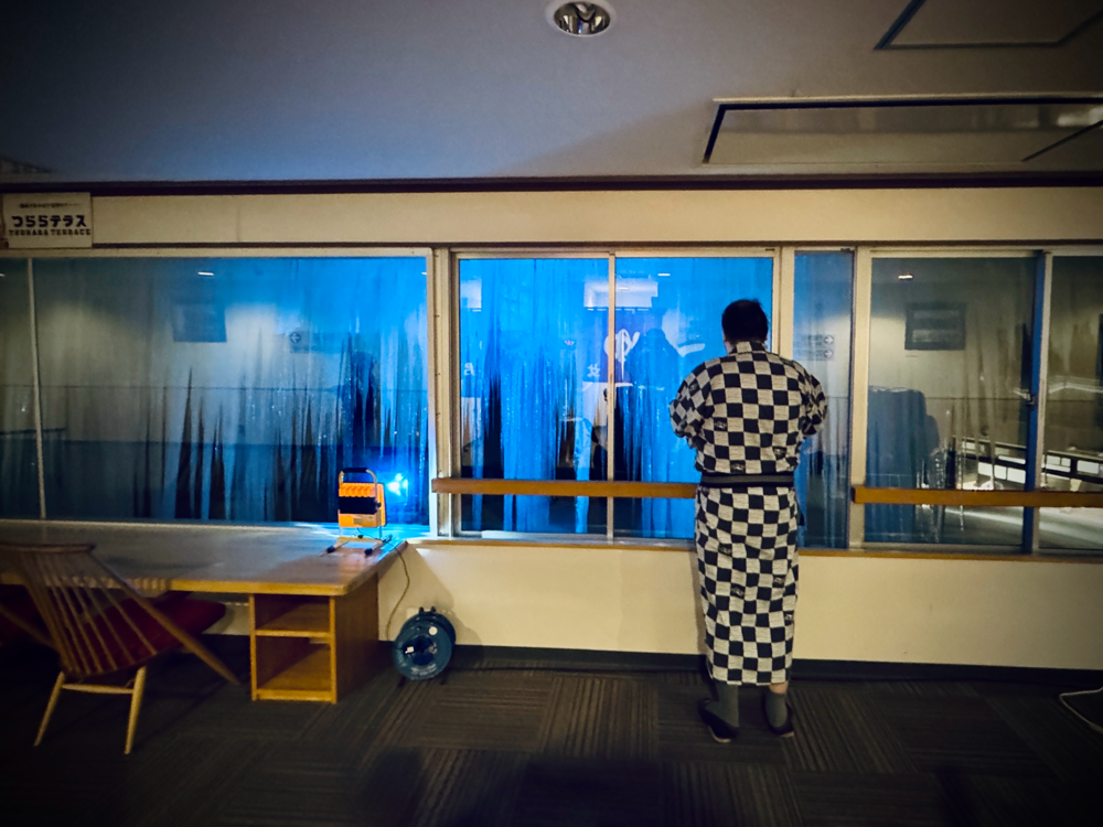 Eine leere Skipiste im Sonnenschein mit bewaldeten Bergen im Huntergrund