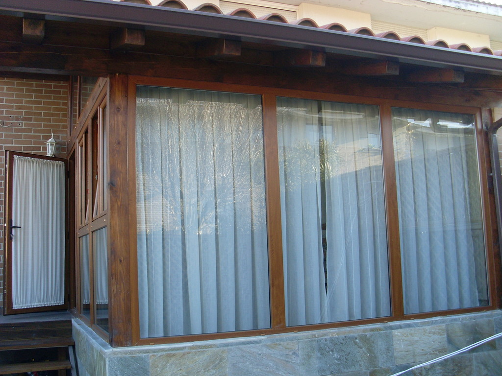 Porche de madera con ventanales fijos