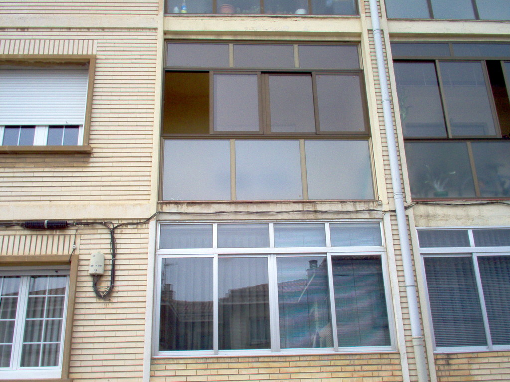 Cerramiento de terraza con ventanas correderas en color bronce