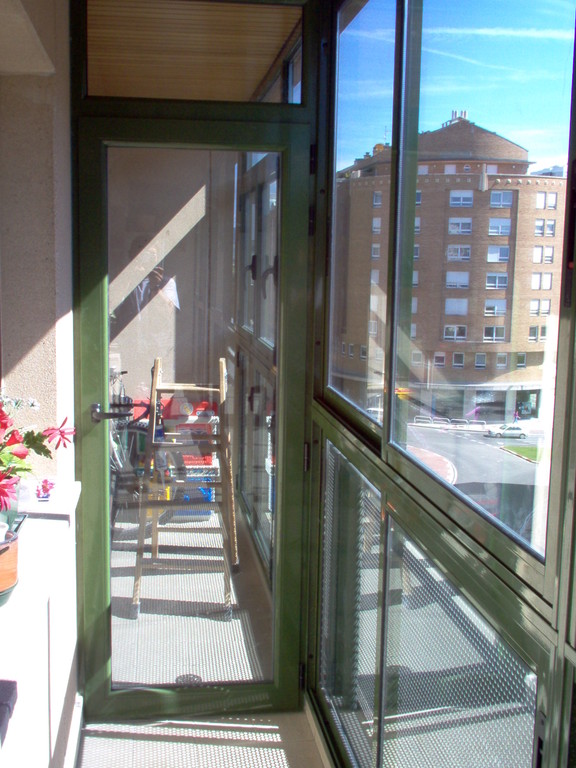 Cerramiento de terraza con ventanas correderas y puertas abisagradas