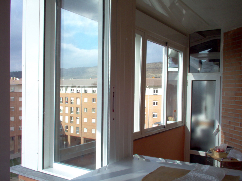 Cerramiento de terraza con ventanas correderas y persianas