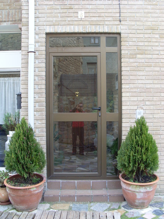 Puerta de entrada a portal en aluminio anodizado bronce