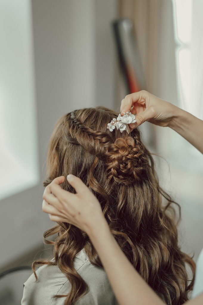halboffene Frisur mit Locken, Fishtailzopf und Zopfblume hinten wird geschmückt
