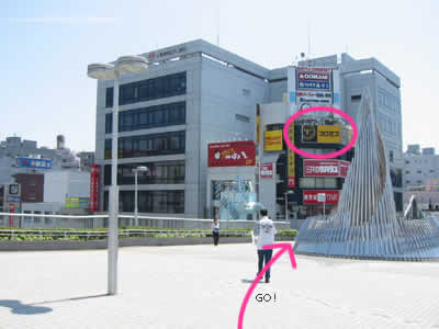 ４．外の広場に出ました。広場を横切って、プロミスの看板のほうへ進みます。