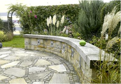 Beleuchtbare Natursteinmauer mit Eichenholzsitzfläche