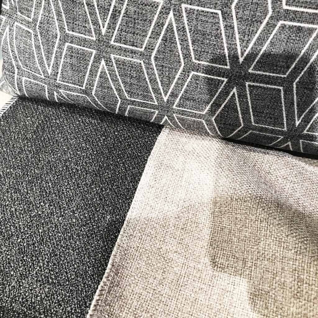 Beiger und anthrazit farbener Stoff kombiniert mit einem grafisch gemusterten Stoff. Auswahl für ein Moodboard.