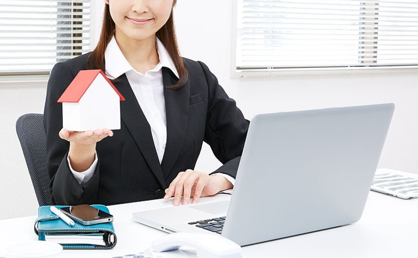 家の模型を手に持ってマスター認定講座をオススメする女性