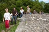 Eine Gruppe erkundet die Burg und läuft auf einem Weg der Ruine entlang.