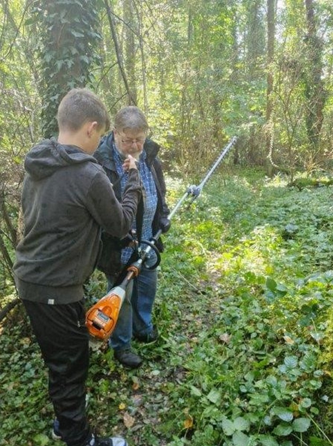 Ernst und Fabian besprechen, welche Wege von Fabian mit der Akku-Schere noch freigeschnitten werden sollen.