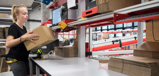 Eine Mitarbeiterin bereitet ein Paket für den Versand vor.