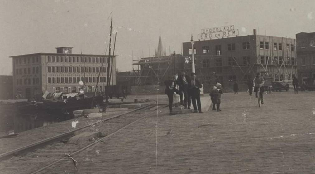 Foto uit 1924 van de Kanaalkade Alkmaar, links het kaaspakhuis, rechts de in aanbouw zijnde chocoladefabriek Ero en Rem
