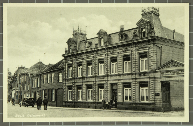 Oude foto van het pand, met rechts de poort met bedrijfsreclame