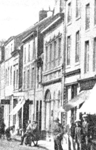 Oude foto van de Putstraat, waarop de winkelpui onder rondboog zichtbaar is.