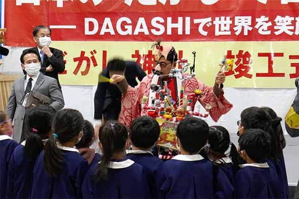 チンドン屋さん(秋山代表理事)と園児らの「だがしと笑顔の交換」