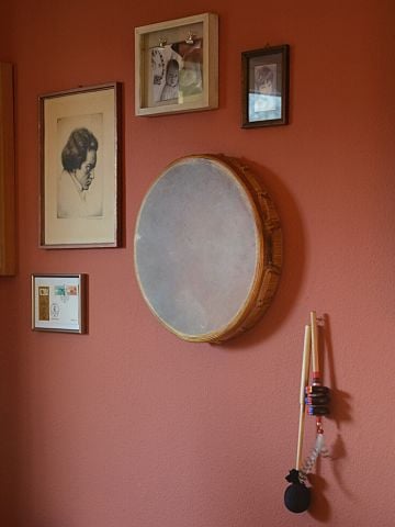 Trommel, Schlägel, und Bilder hängend an einer Wand
