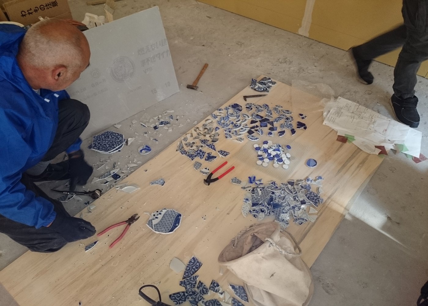 フィルメランジェ店舗こだわりの床素材セレクト中。古い絵皿を加工して床にちりばめます。
