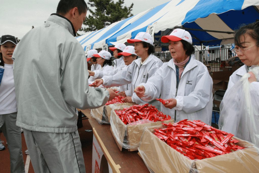 【第17回大会（2007年）】こちらは主会場でエイドに従事する女性団体の方々。コース上の給水エイドもそうですが、女性の方々の明るさ・はつらつさに力をもらったランナーは数多くいることでしょう。