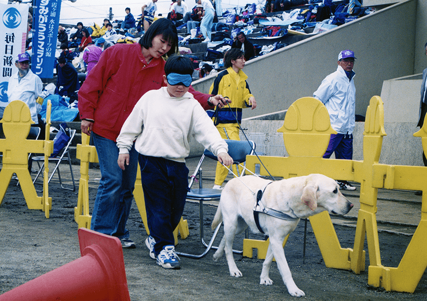 【第10回大会（2000年）】毎年大会主会場では盲導犬体験コーナーを設置。ランナーの皆様からの参加料の一部は、盲導犬育成助成金として役立たせていただいています。