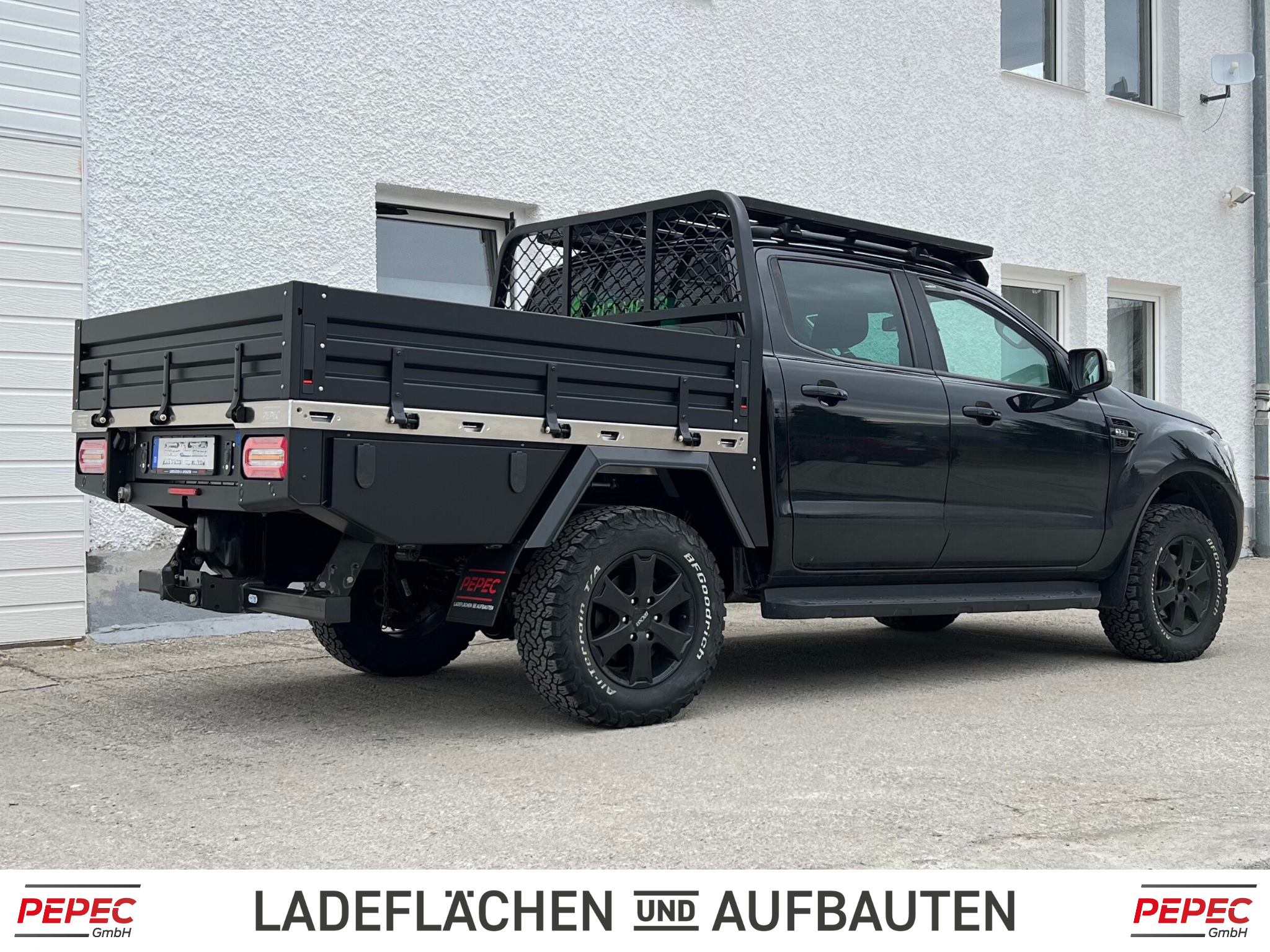 Pickup mit Flachpritsche, ausgestattet mit klappbaren Bordwänden und Dachträger, ideal für Transport- und Offroad-Einsätze