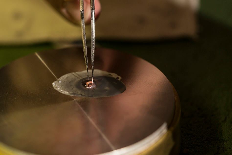 Schwarzpolitur eines Uhrwerkteils auf einer Zinnplatte