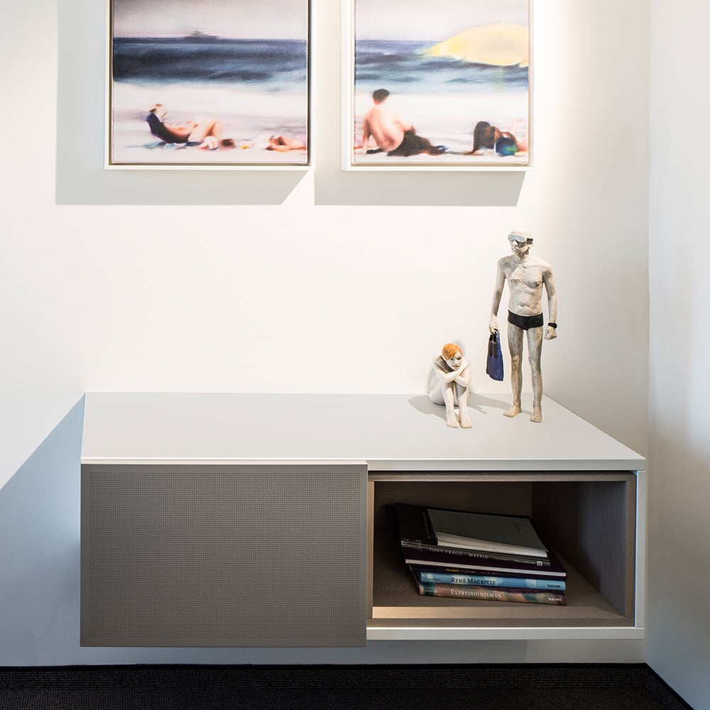 The wall-mounted lowboard has one sliding door with acoustically effective micro-perforations. 