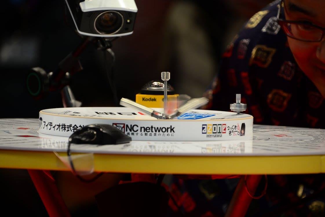 土俵の端に刺さって下に降りてきませんが、このコマの仕組みと「回し方」だと比較的簡単に土俵の端に「置く」ことができます。