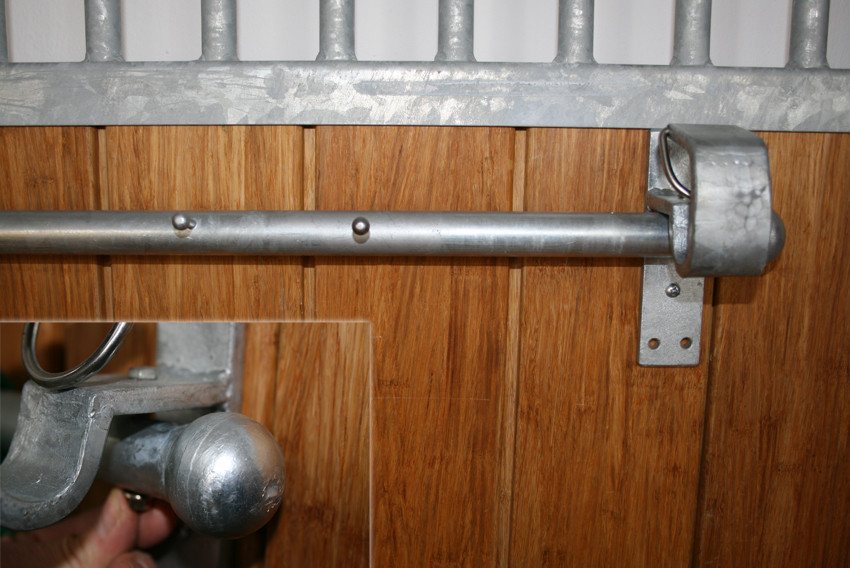 Die Stange hinten ist fest am Bügel angeschraubt. Hier sehen Sie auch die Stifte, die die Seitenteile des Netzes sicher im Innern der Raufe halten.