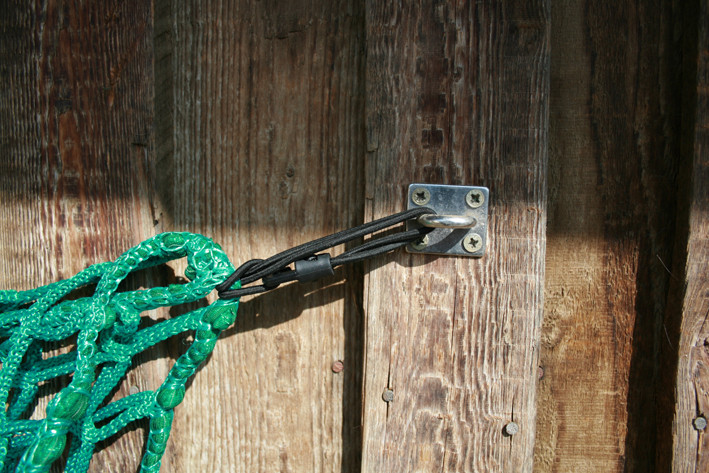 Befestigung mit Gummispanner als Sollbruchstelle, sollte sich doch einmal ein Pferd im Netz verfangen.