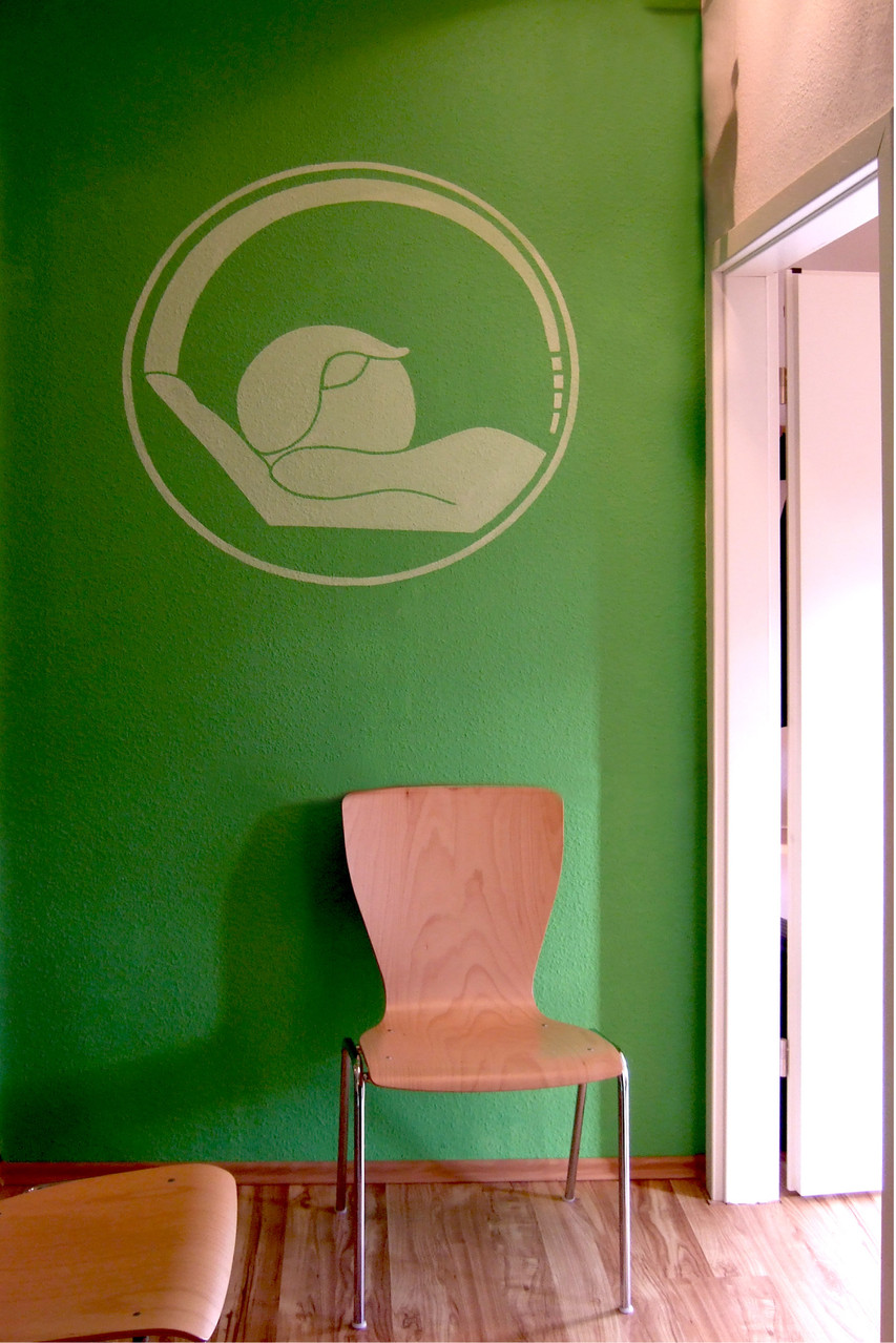 Ganzheitliche Gestaltung | Übertragung des Logos auf die Wand ggü. des Eingangs sowie Abstimmung der Wandfarbe auf die Logofarbe