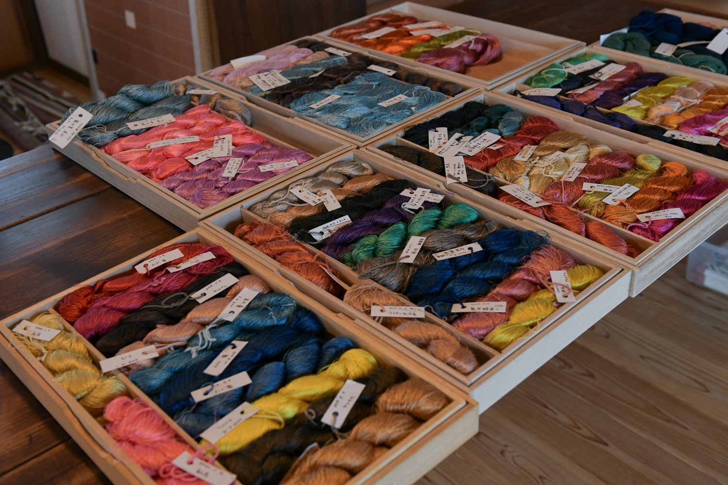 ▲草木染めした絹糸。草木工房の講座で染めた絹糸（手前）、自宅で染めた絹糸（左上）。