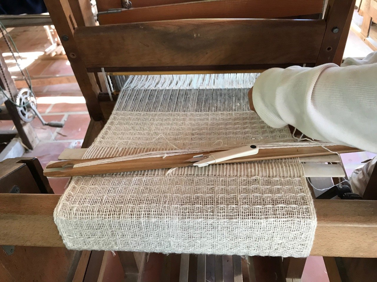 ▷日本から運ばれた織り機を整備してスタッフにワッフル織りを教える（★）