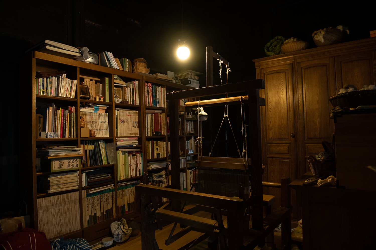 ▲織り機のかたわらには本棚。父や祖父から受け継いだ本も。