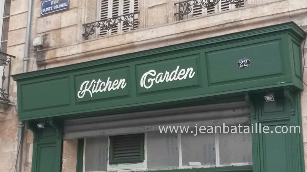 Lettres peintes sur devanture de restaurant bio en bois
