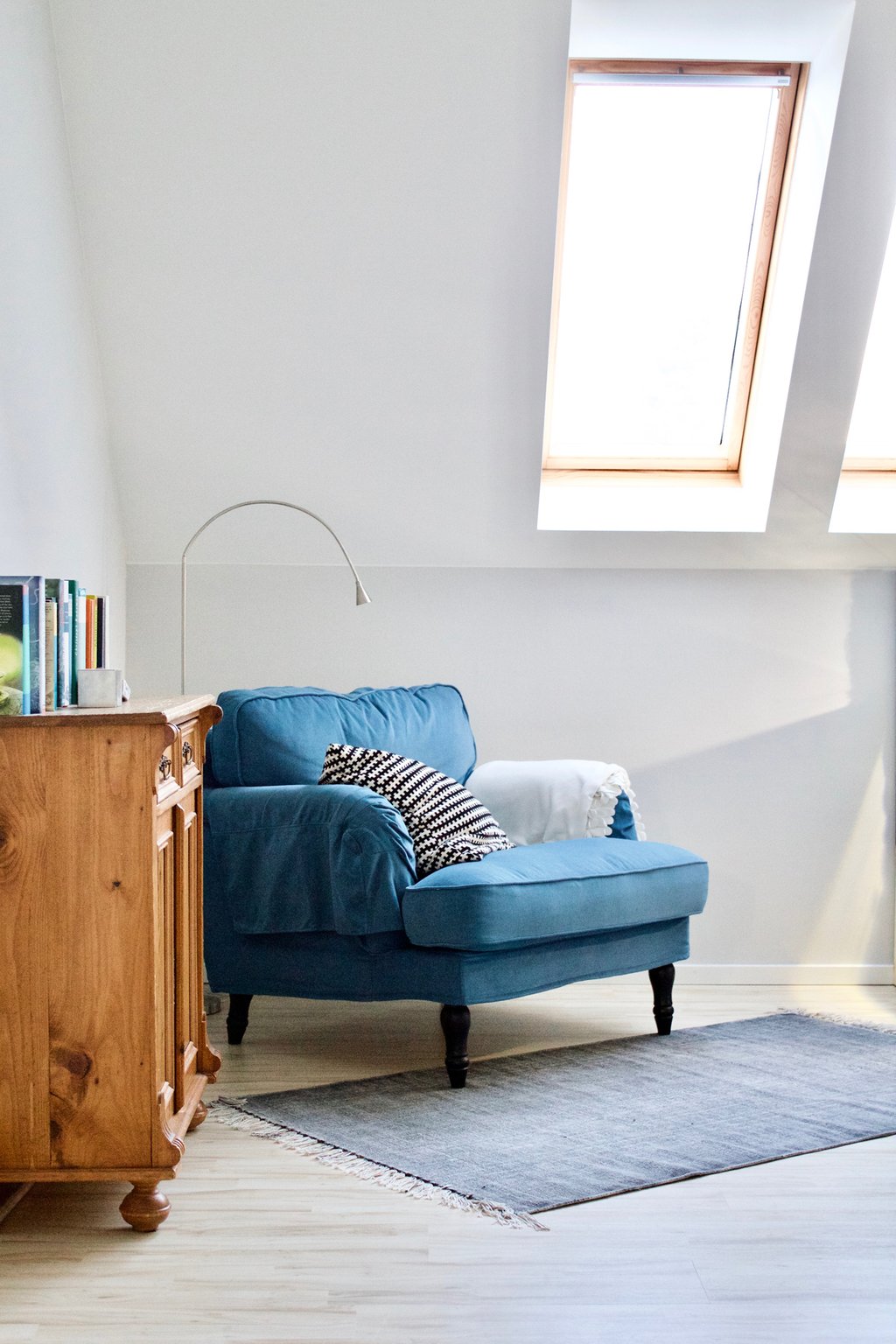 Fam. Z. | Galerie | Hellgraue Wand | Blaugrauer Sessel | Grauer Teppich