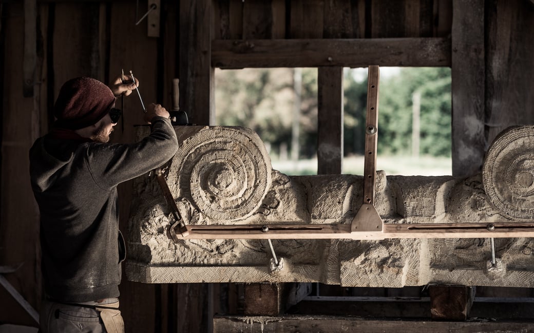 Steinmetz arbeitet an einem Bildhauerstück aus Sandstein