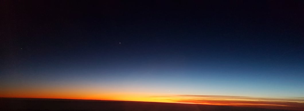 Sonnenuntergang mit Mondsichel (bei Vergrößerung über dem Horizont erkennbar) und Sternen (Planeten?), aufgenommen am 27.12.2019 aus dem Flugzeug