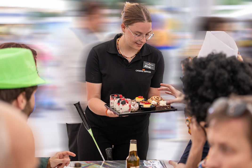 Aline serviert schwungvoll eine feine Dessertauswahl im Festzelt auf dem Brünig.