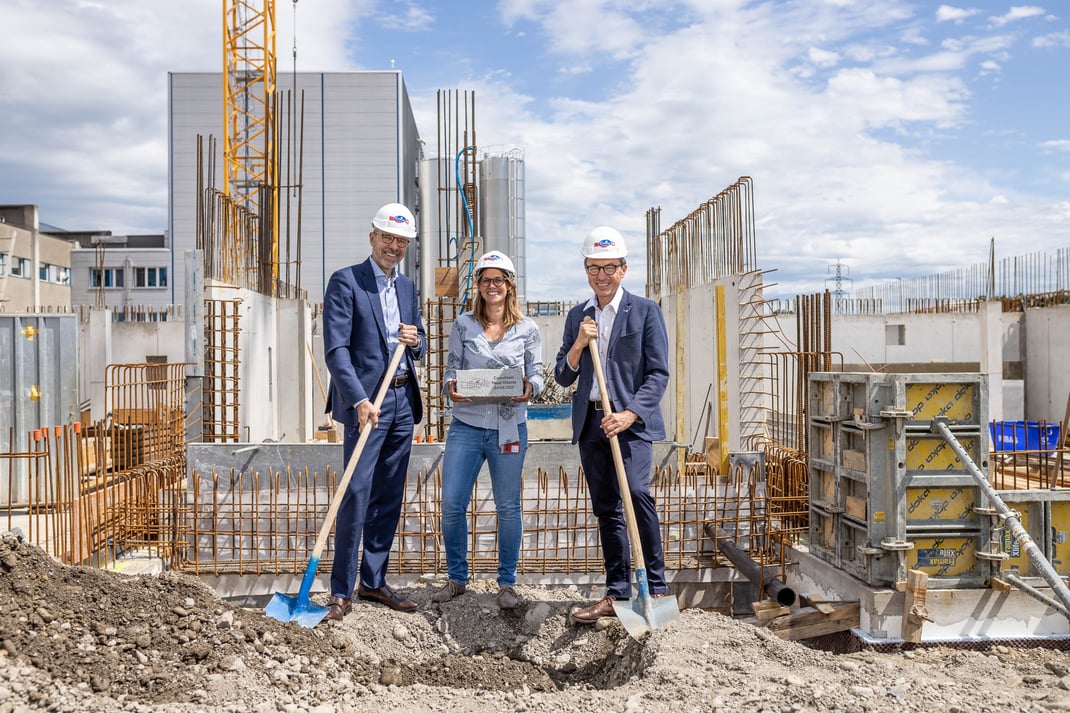 Emmi-Schweiz-Chef Marc Heim (links), Ann-Kathrin Kleinthomä, Projektleiterin und Josef Wyss, Leiter Geschäftsbereich Käse, bei der Grundsteinlegung.