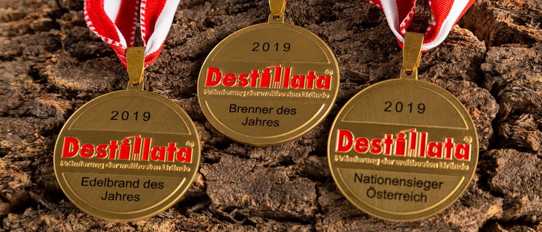 3 Medaillen auf Baumrinde: Edelbrand des Jahres, Brenner des Jahres, Nationensieger Österreich