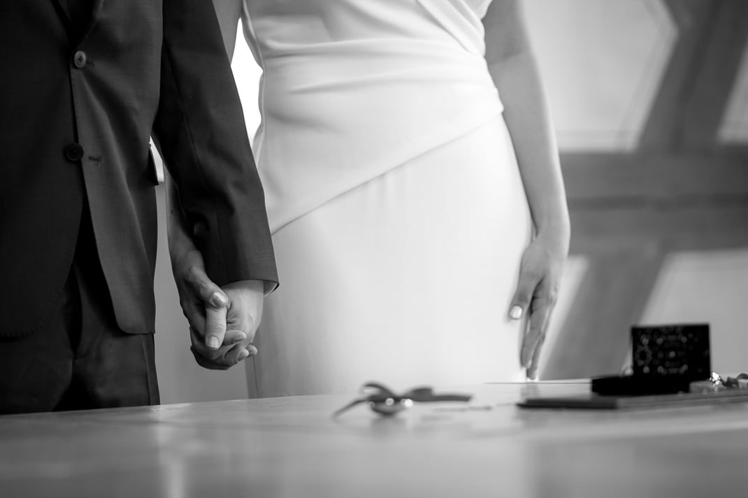 Bild eines Brautpaares das sich vor dem Altar die Hände hält