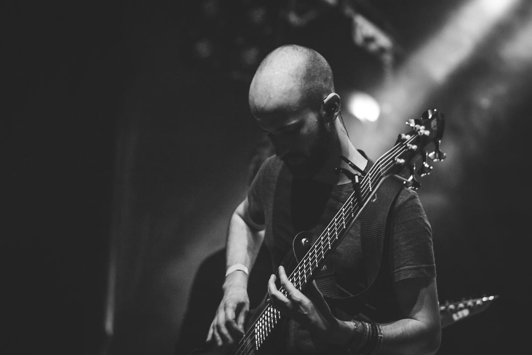 Mann mit gesenktem Blick der einen E-Bass spielt